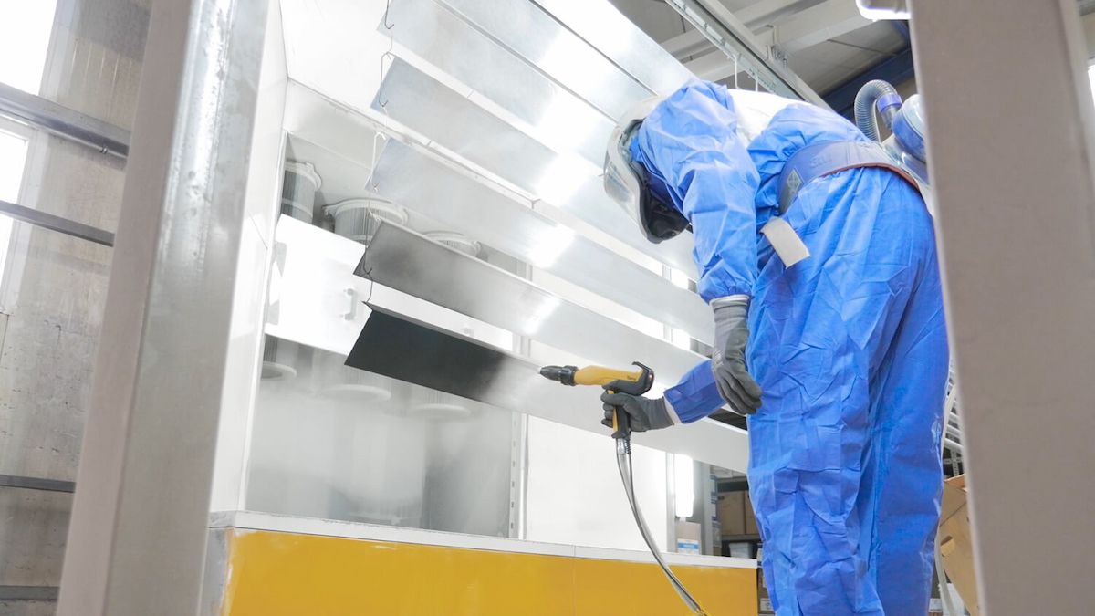 Mitarbeiter trägt eine Pulverbeschichtung auf